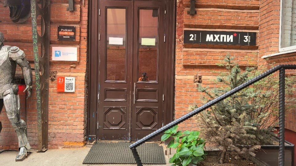 Вход в Московский художественно-промышленный институт на «Красном Октябре»: кирпичный фасад, табличка «МХПИ» и фигура рыцаря у дверей