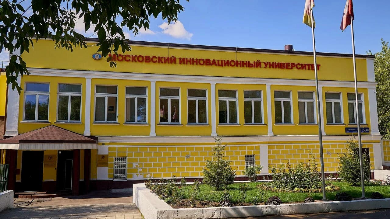 Корпус Московского инновационного университета на Краснобогатырской улице: жёлтый фасад с названием университета и флагштоками