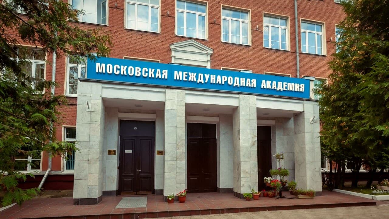 Главный вход Московской международной академии на Новомосковской улице: портик с колоннами и вывеска академии на кирпичном фасаде