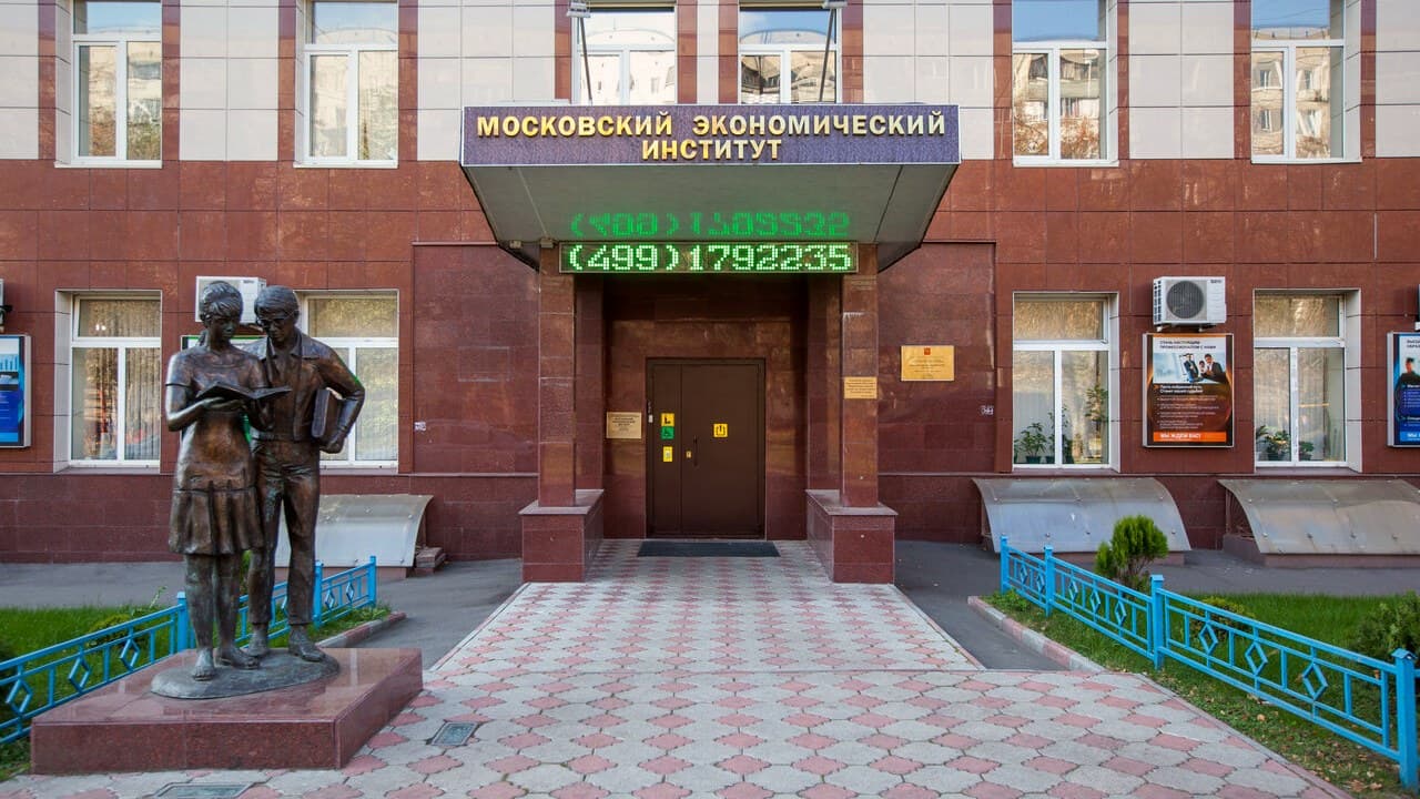 Вход в Московский экономический институт на улице Артюхиной: козырёк с названием и скульптура студентов